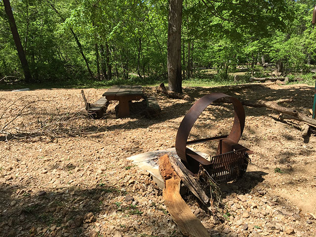 (image) Fire Ring damaged with about 6 inches of rock and dirt depoisted under picnic table.