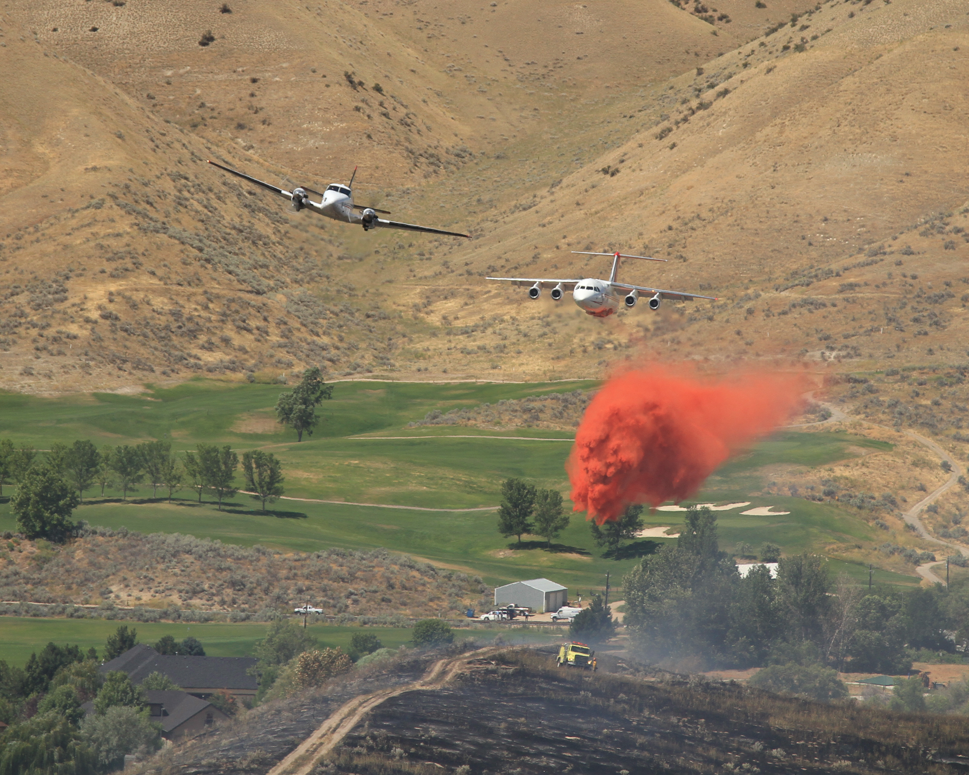 Lead plane with a large airtanker dropping fire retardant