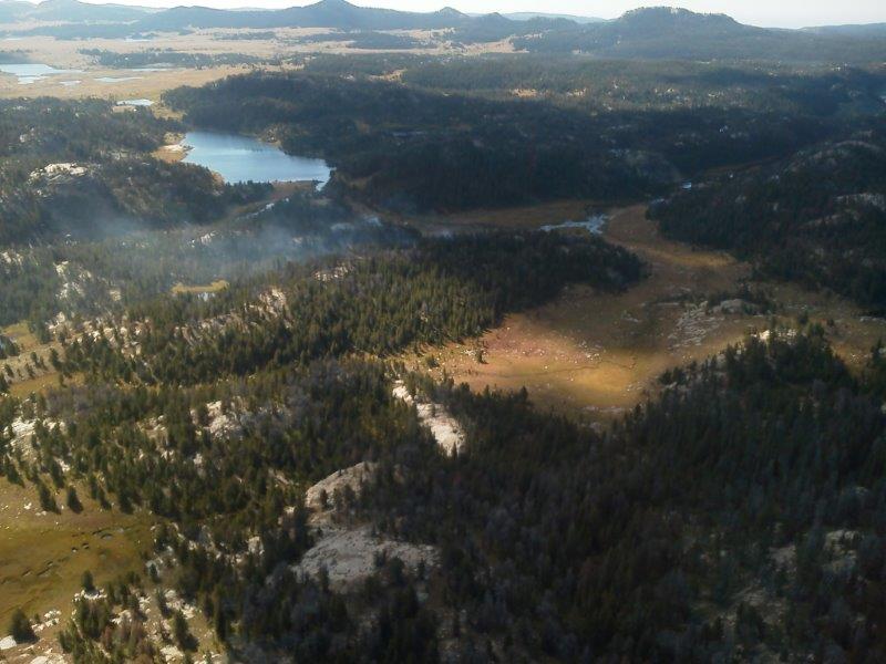 Arial view of Sandpoint Fire located within the Bridger Wilderness of the Wind River Range. Fire is smoldering in mixed conifer stands located at 9500’ elevation. The Continental Divide trail can be seen within the high mountain meadows.