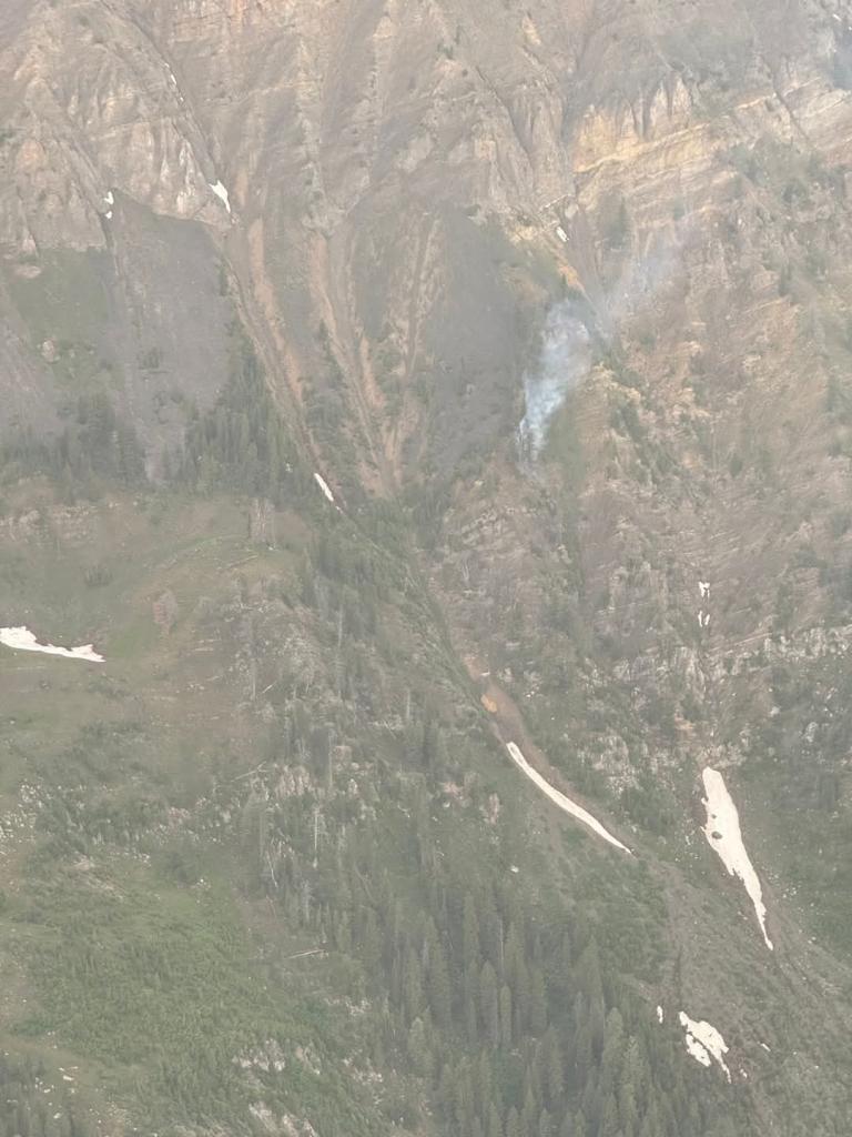 Steep rocky canyon with smoke column.
